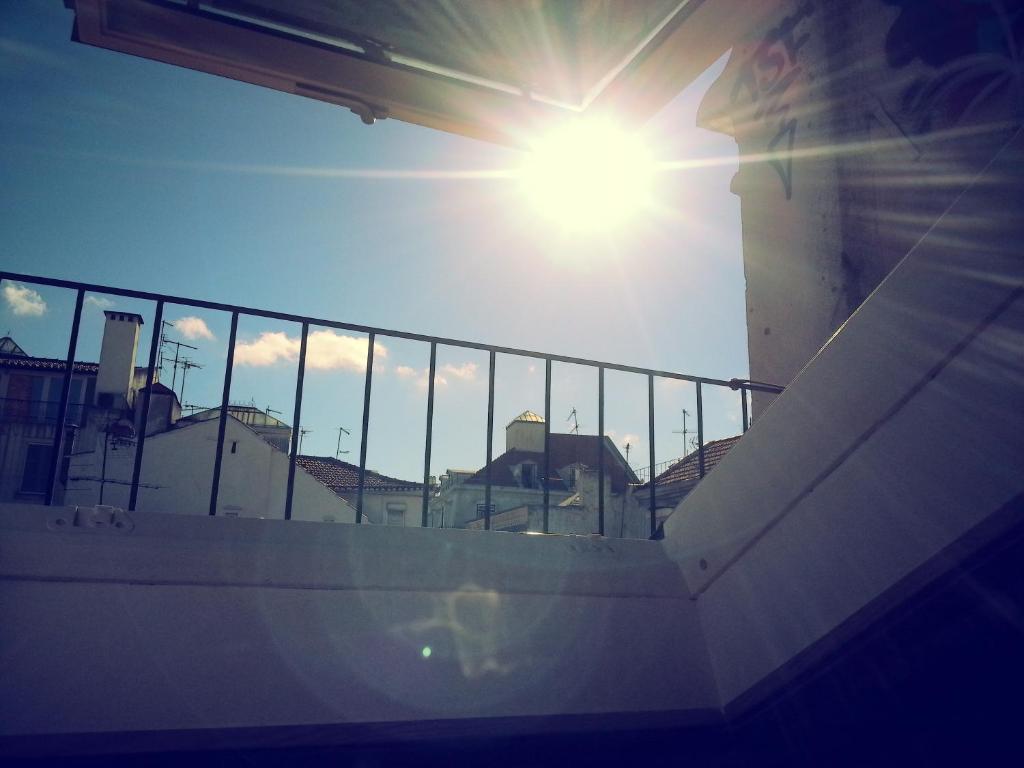 リスボンにあるAtalaia Duplexの背景の塀の後ろに輝く太陽