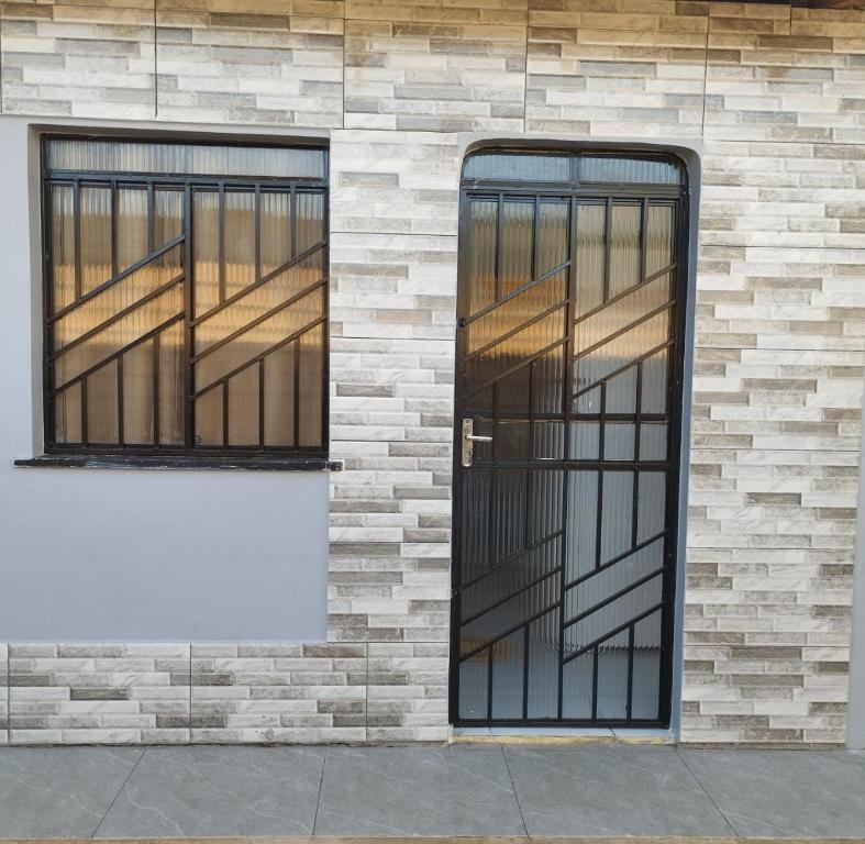 ein Backsteingebäude mit einer Tür und zwei Fenstern in der Unterkunft Apartamento Aconchegante in Boa Vista