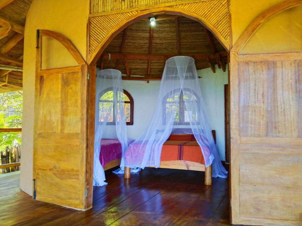sypialnia z 2 łóżkami i zasłonami w obiekcie Casa Magica w mieście Minca