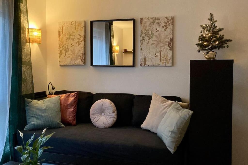 - un salon avec un canapé, des oreillers et un miroir dans l'établissement Cozy’Wood, à Brest