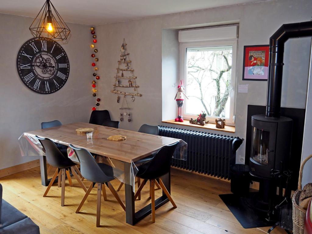 a dining room with a table and a stove at Appartement Maison Vosgienne La Bresse Centre in La Bresse