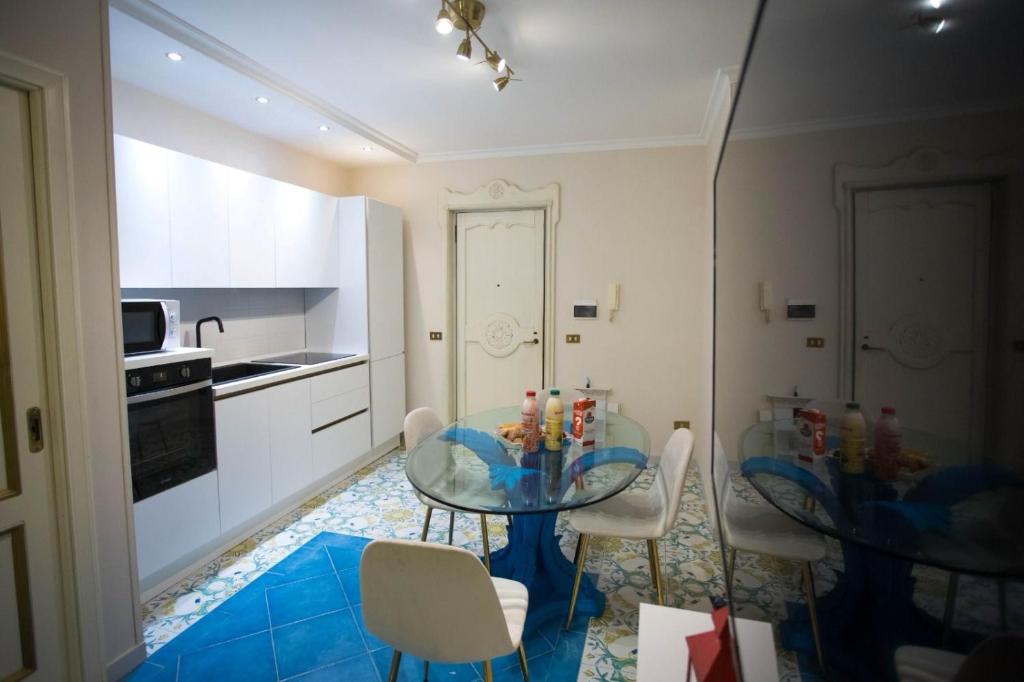 kuchnia i jadalnia ze szklanym stołem i krzesłami w obiekcie Hause Naty spaccanapoli w mieście Napoli