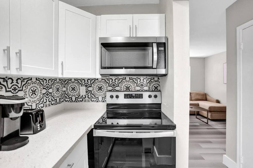 a kitchen with a stove and a microwave at Pionciana Getaway 1BR Apartment Near FLL Airport in Fort Lauderdale