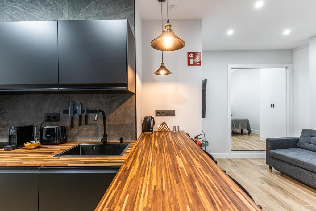 a kitchen with a wooden counter top and a sink at VR LATINA APARTMENTS in Madrid