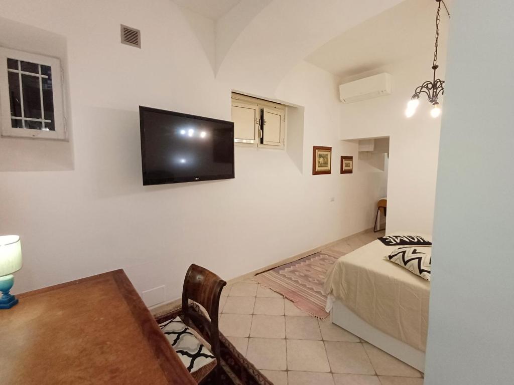 Un dormitorio con una cama y un televisor en la pared. en Gianicolo Sweet Home, en Roma