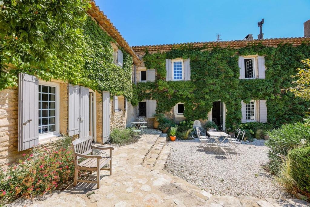 una casa de piedra con un banco delante en le mas du lavoir, en Gordes