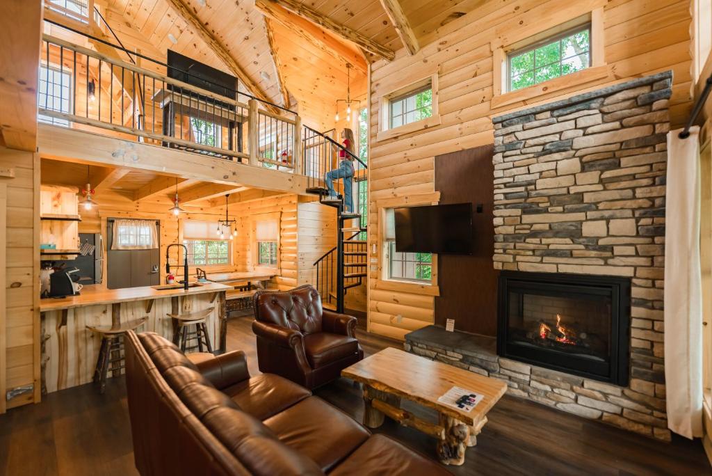 Cabaña de madera con sala de estar con chimenea en Skyview Treehouse by Amish Country Lodging, en Millersburg