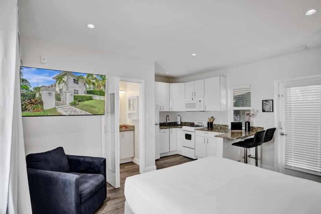ein weißes Schlafzimmer mit einem Bett und einer Küche in der Unterkunft Beach Isles Modern Studio Apartment in Fort Lauderdale in Fort Lauderdale