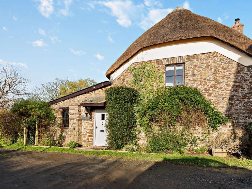 an old brick house with a thatched roof at 3 Bed in Bishops Tawton 75872 in Umberleigh Bridge