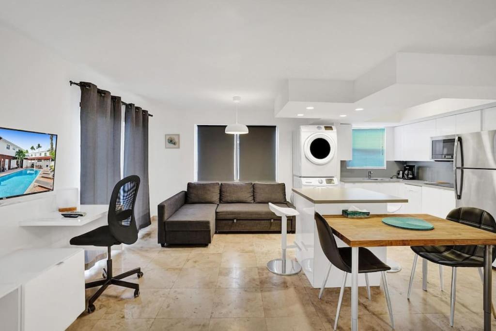 a kitchen and living room with a couch and a table at Waves Beach Town 2BR Apartment in Pompano Beach