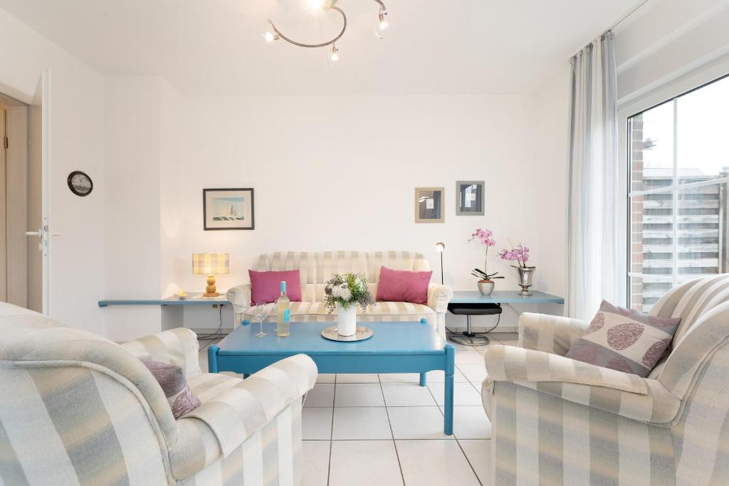 een woonkamer met een blauwe tafel en 2 stoelen bij Wohnpark Heisterbusch Ferienhaus Kamphans in Kellenhusen