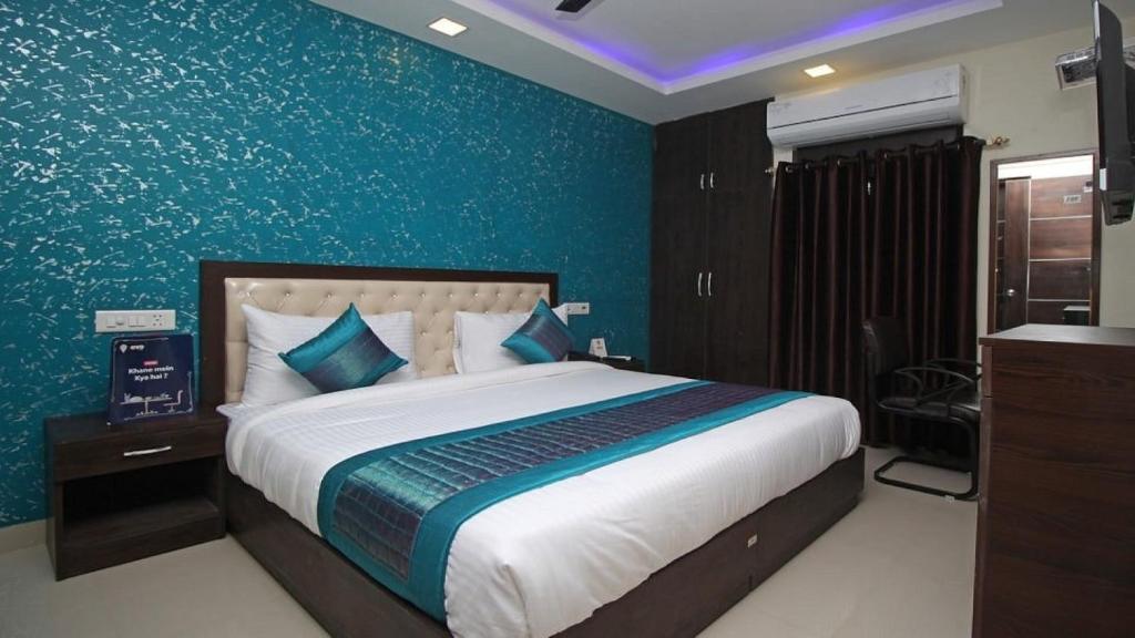 1 dormitorio con 1 cama grande y pared azul en Airport T Palace, en Nueva Delhi