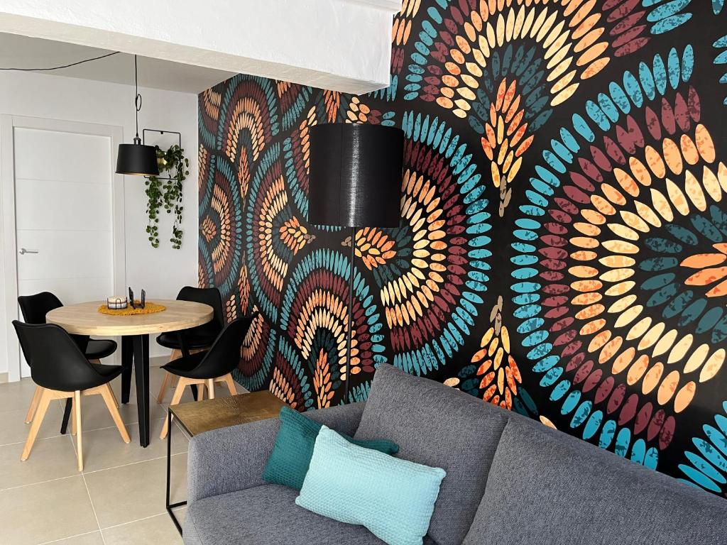 a living room with a couch and a colorful wall at Casa Zizi in Costa Calma