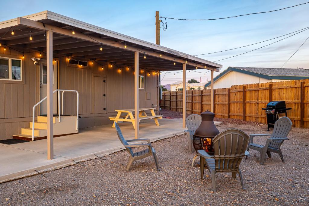 d'une terrasse avec des chaises, un barbecue et un foyer extérieur. dans l'établissement Cozy Desert home, Stunning Views, Peaceful Vibes Near Laughlin, à Bullhead City