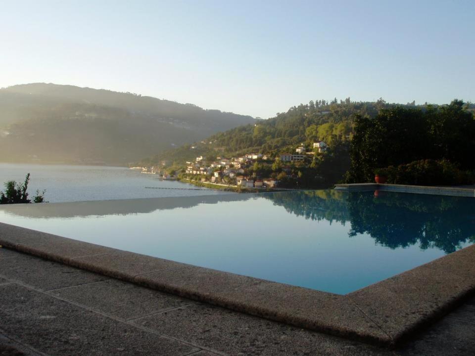 une grande piscine avec vue sur la rivière dans l'établissement Casa da Torre, Porto Manso, à Ribadouro