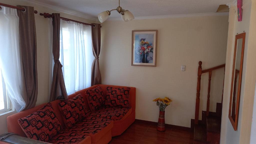 sala de estar con sofá rojo y ventana en Casa Arriendo en Dichato, en Tomé
