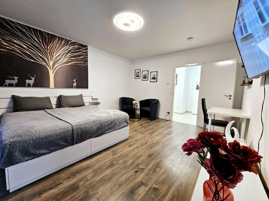 een slaapkamer met een bed en een vaas met bloemen bij 2-Zimmer, Balkon, Parkplatz in Mülheim an der Ruhr