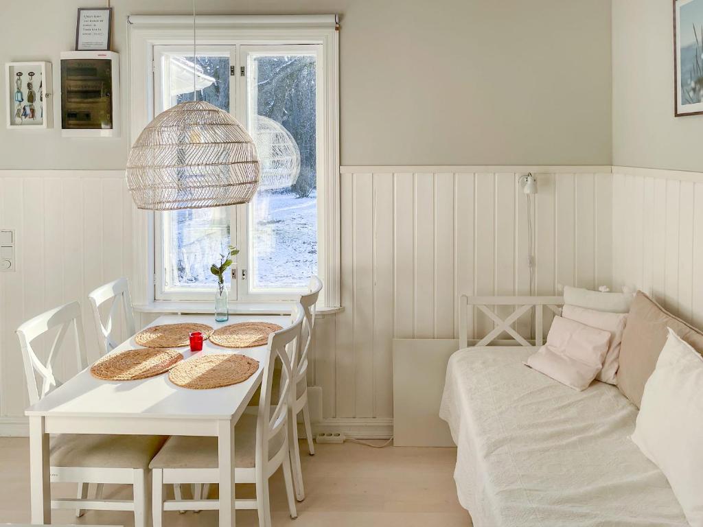 a white dining room with a table and a bed at Villa Primavera Apartment in Hanko in Hanko