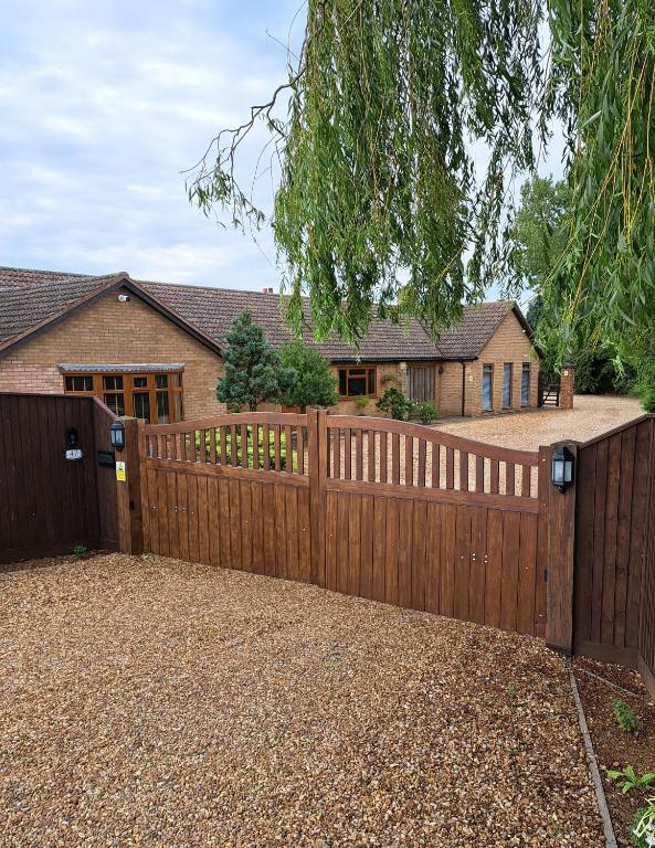 a wooden fence in front of a house at Highfields Holidays bed & breakfast in Peterborough