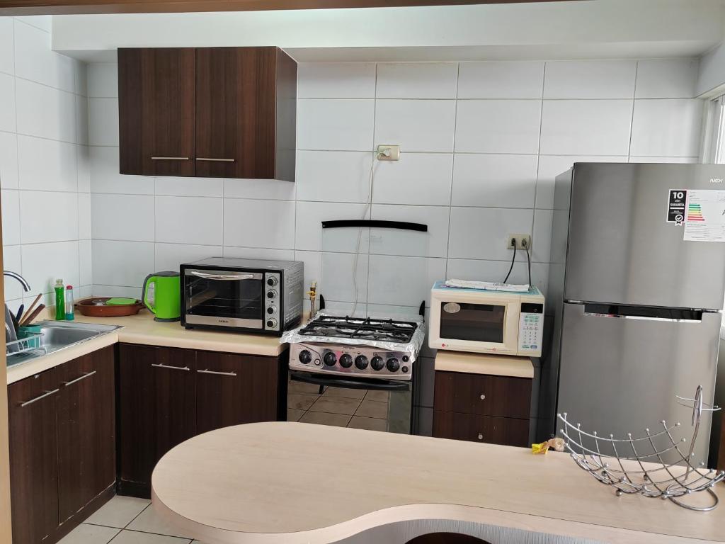 una cocina con electrodomésticos de acero inoxidable y armarios marrones en Arriendo Diario En La Serena, en La Serena