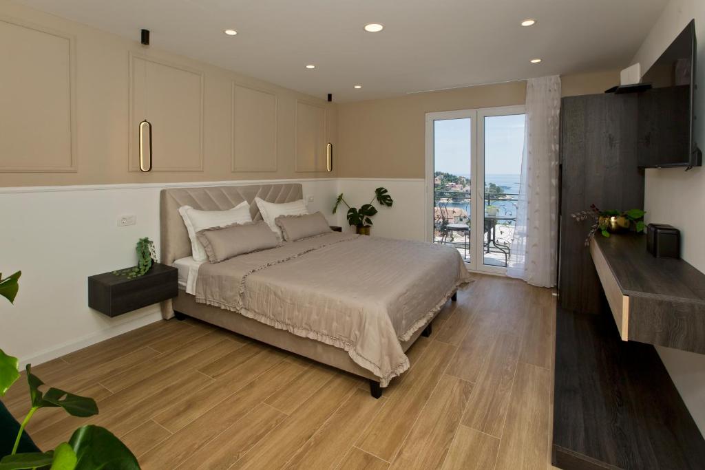 um quarto com uma cama grande e uma janela grande em Villa Milton Luxe Rooms em Hvar