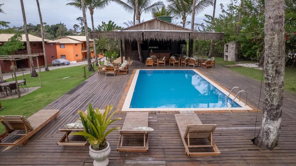 una piscina en una terraza de madera junto a una casa en Trancoso43 - Lindo apartamento 1 suíte , sala com varanda, en Trancoso