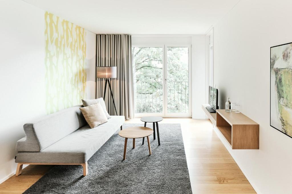 uma sala de estar com um sofá e uma mesa em APPADU Appartements em St. Gallen