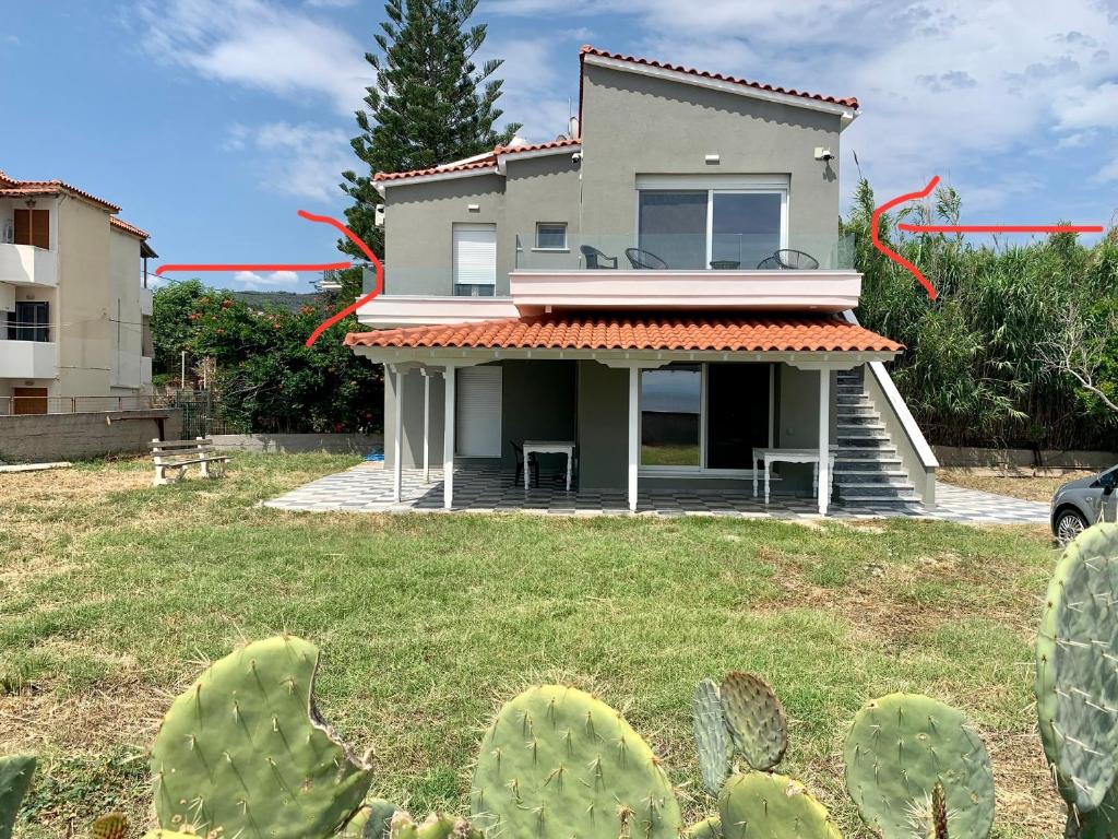a house with a cactus in the yard at Seafront Apartment in Skala Mistegnon