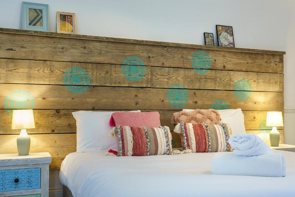 a bedroom with a bed with a wooden headboard at The Steam House - 3 Bedroom Townhouse in Bath by Mint Stays in Bath