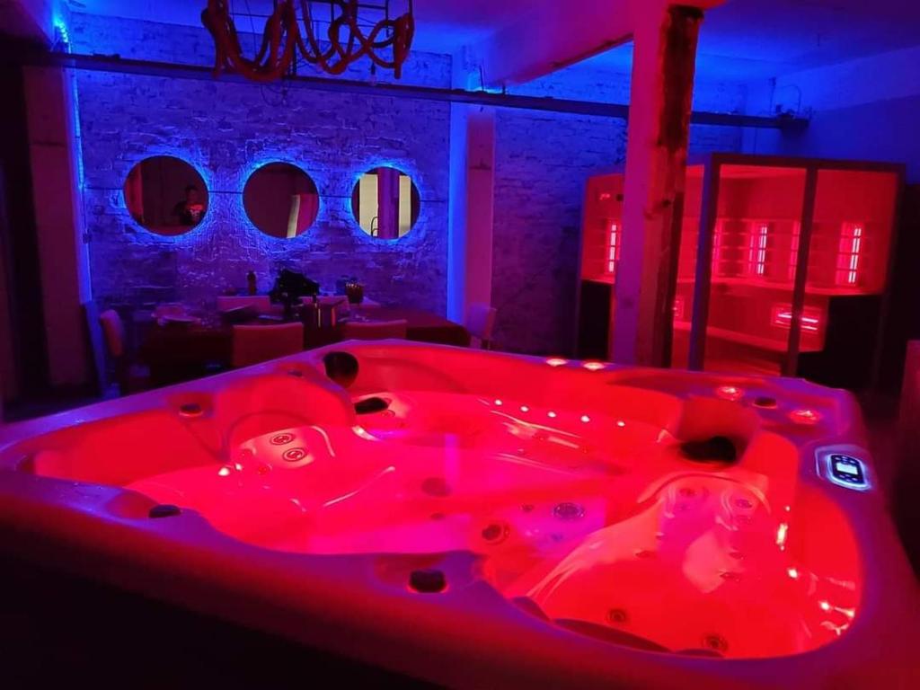 una vasca da bagno rossa in una stanza con luci rosse di SPA industrial Loft in einem ehemaligen Umspannwerk a Essen