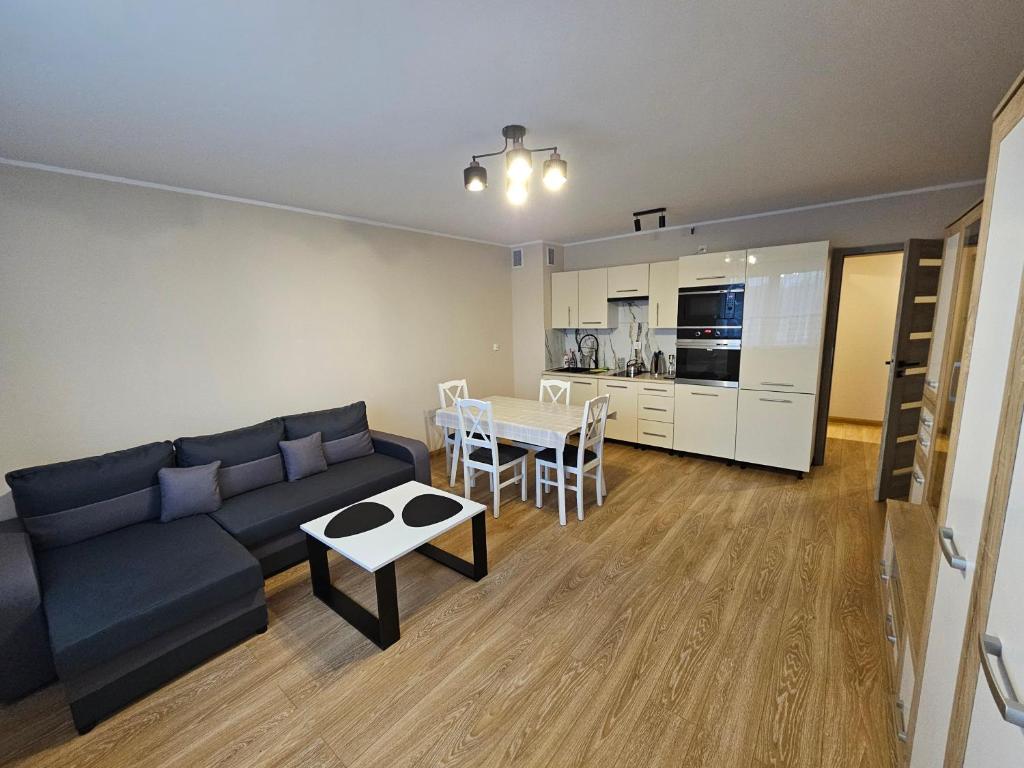 ein Wohnzimmer mit einem Sofa und einem Tisch in der Unterkunft Apartament Nowa Piakowa 2 in Wągrowiec