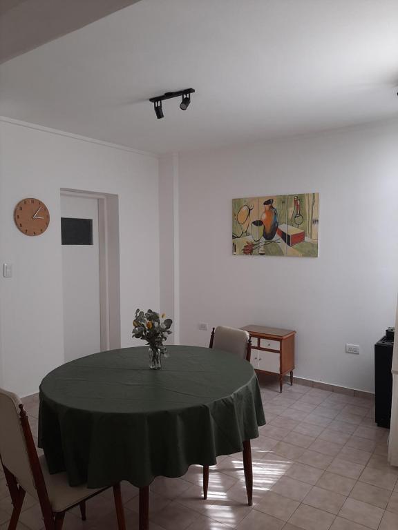 a dining room with a table with a vase of flowers on it at Departamento Interno Divino! in Balcarce