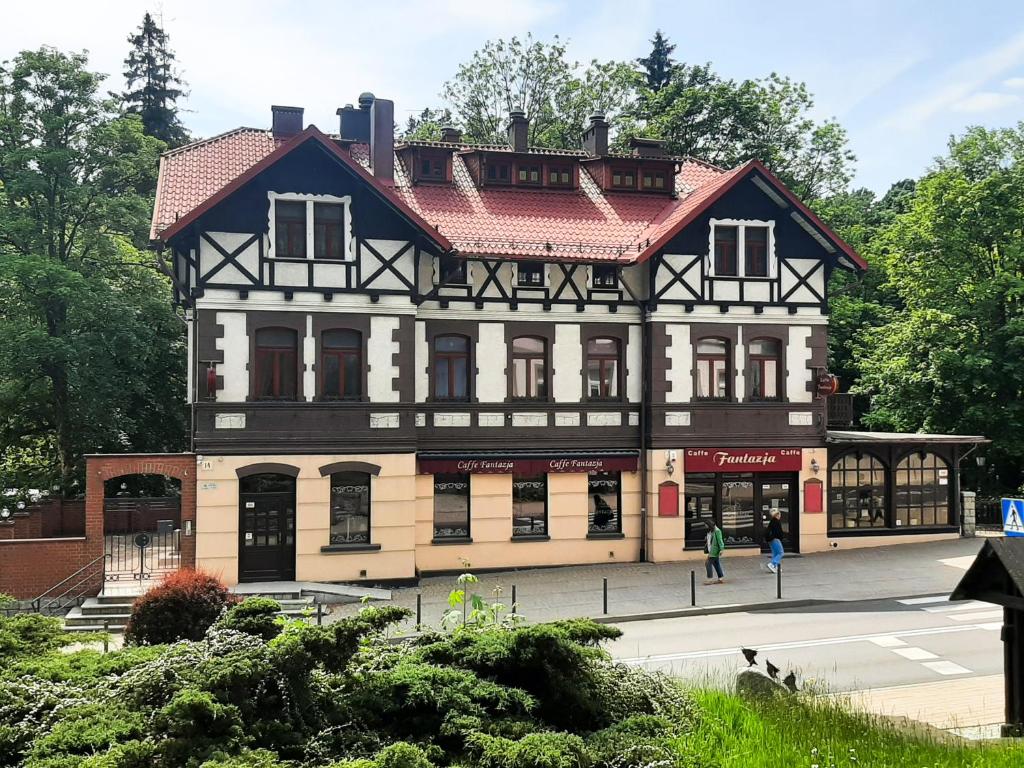 un grand bâtiment avec un toit rouge dans l'établissement Fantazja, à Szklarska Poręba