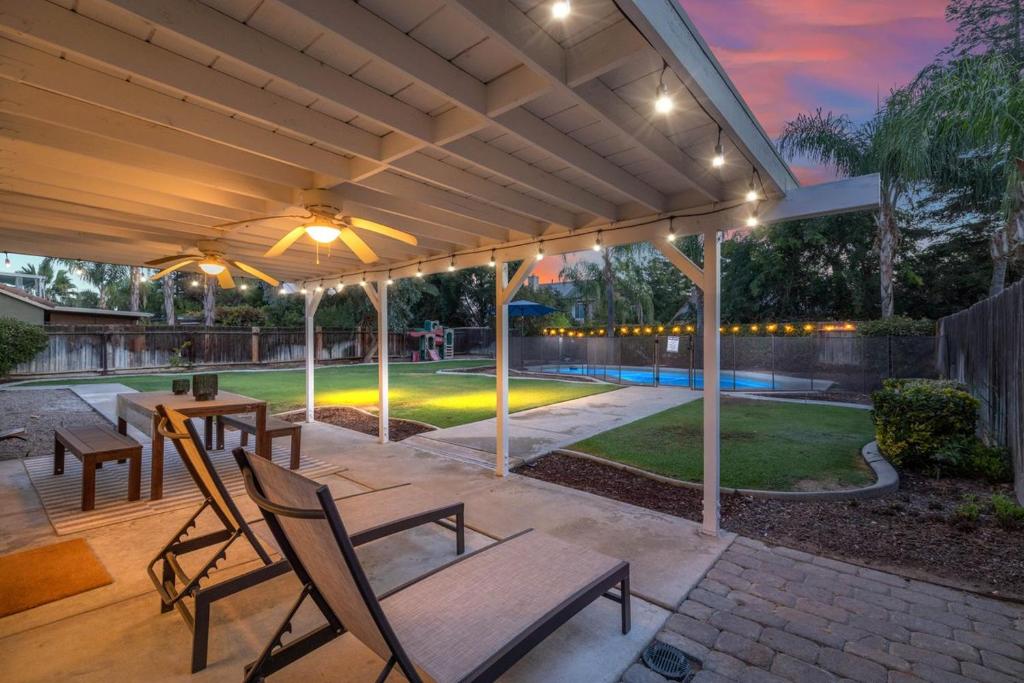 a patio with a table and chairs under a pergola at Revitalizing 3 Bedroom Home With Pool, Pet-Friendly, Wi-fi in Bakersfield