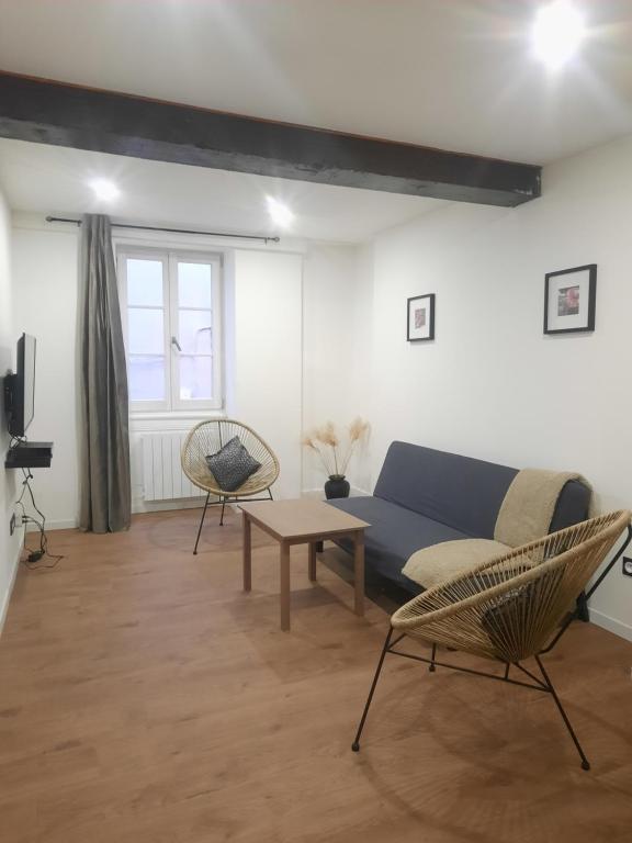 sala de estar con sofá azul y sillas en Le refuge du bonheur, en Trévoux