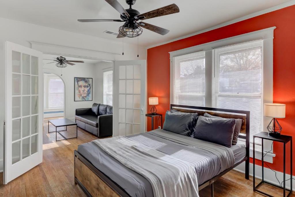 1 dormitorio con paredes rojas, 1 cama y 1 sofá en Charming Cooper-Young Flat in the Heart of Memphis en Memphis