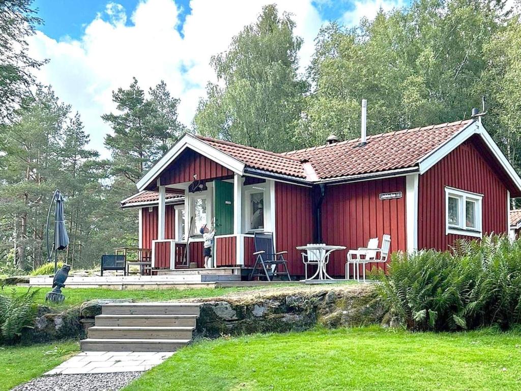 ein rotes Haus mit einem Tisch und Stühlen davor in der Unterkunft Holiday home PRÄSSEBO II in Eckerud