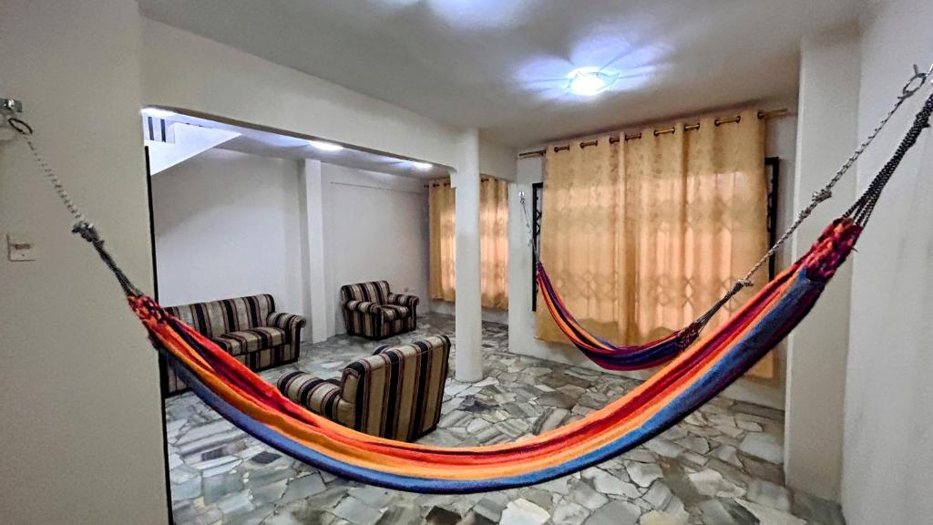 a hammock in a room with two chairs and a couch at NCGSUITE ATARAZANA - Hermosa Casa muy amplia para ti in Guayaquil