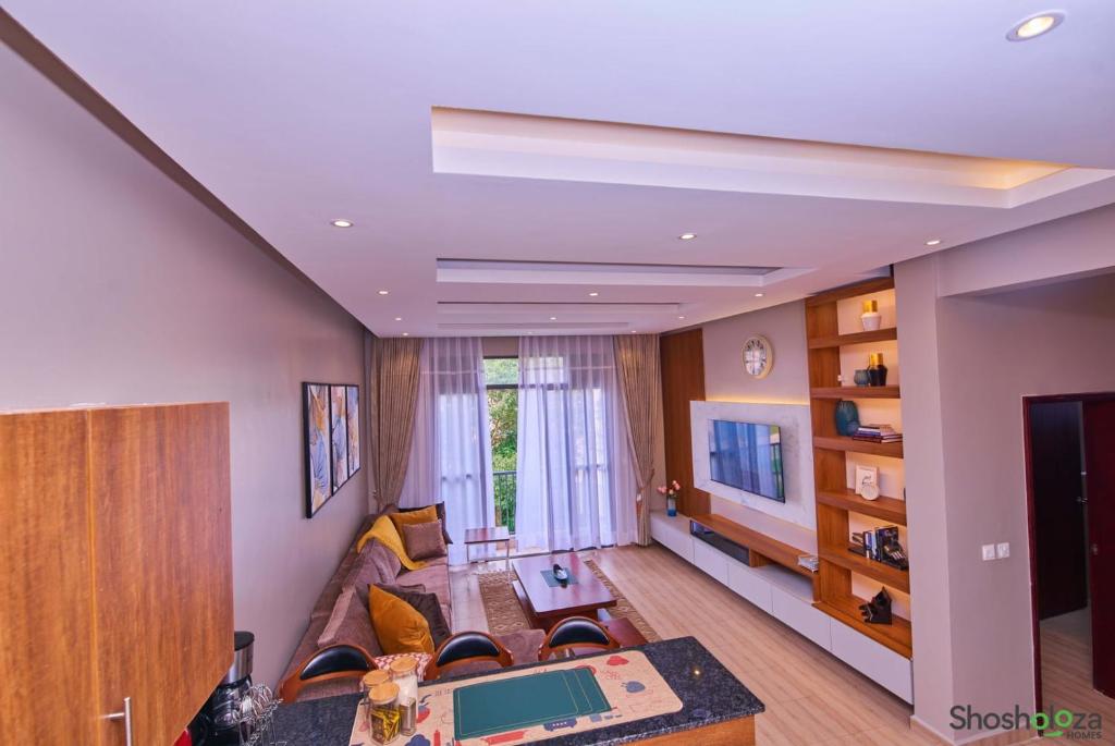 a living room with a couch and a television at Shosholoza Homes in Wakiso