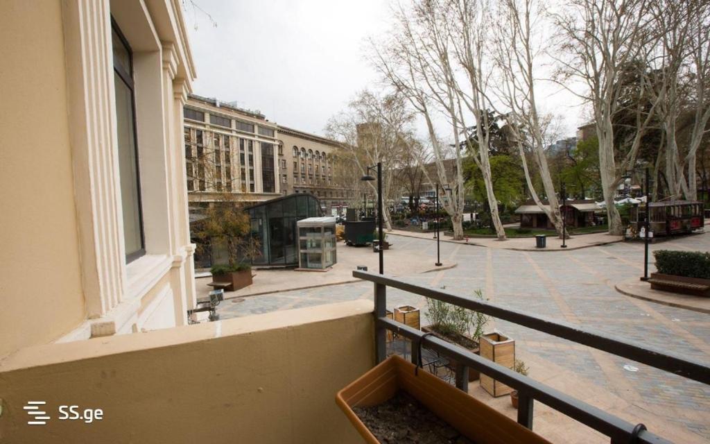 un balcón de un edificio con una calle en el fondo en Happy Orbeliani, en Tiflis
