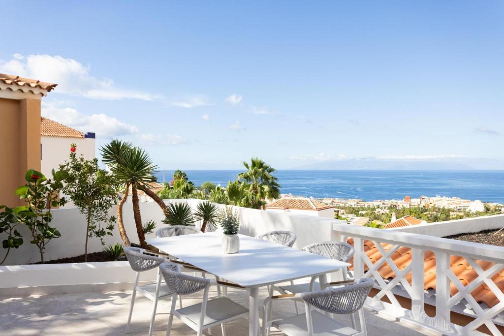 un tavolo bianco e sedie su un balcone con vista sull'oceano di Elysium Ocean Villa ad Adeje