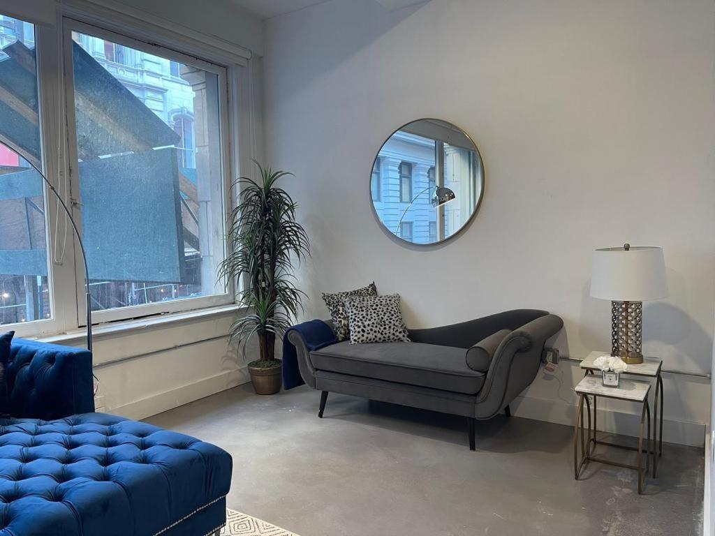 sala de estar con sofá azul y espejo en Large 3 bedroom in Flatiron, en Nueva York