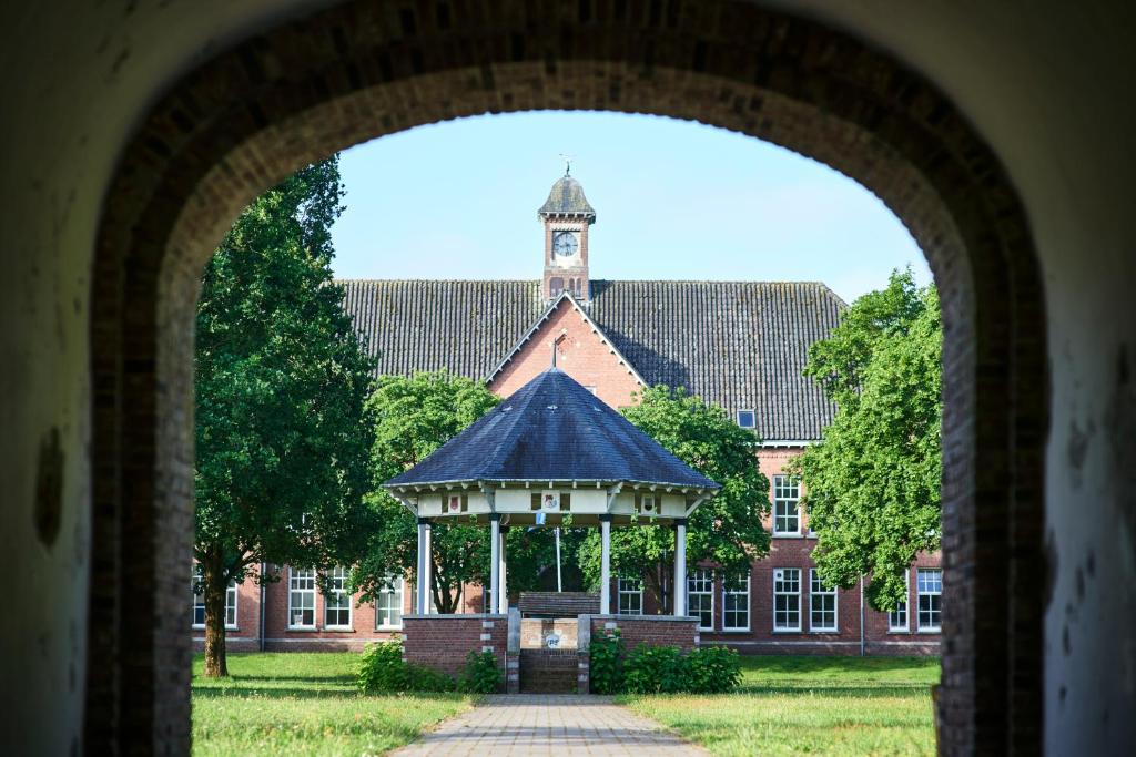 un cenador frente a un edificio con una torre de reloj en Hotel Ryder I Den Bosch - Vught, en Den Bosch