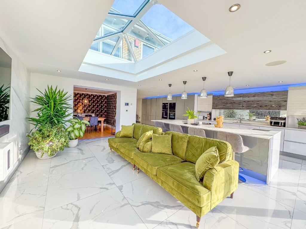 a living room with a green couch and a kitchen at The Firs in Boston