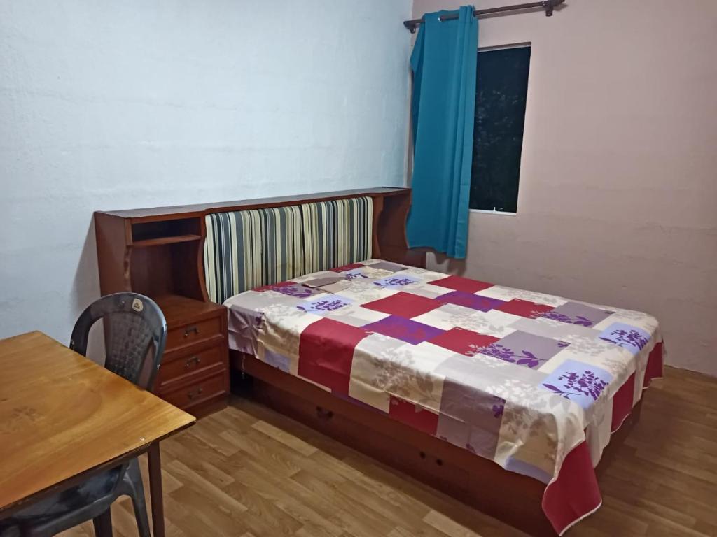 a bedroom with a bed and a wooden table at Irolux House. in Quatre Bornes