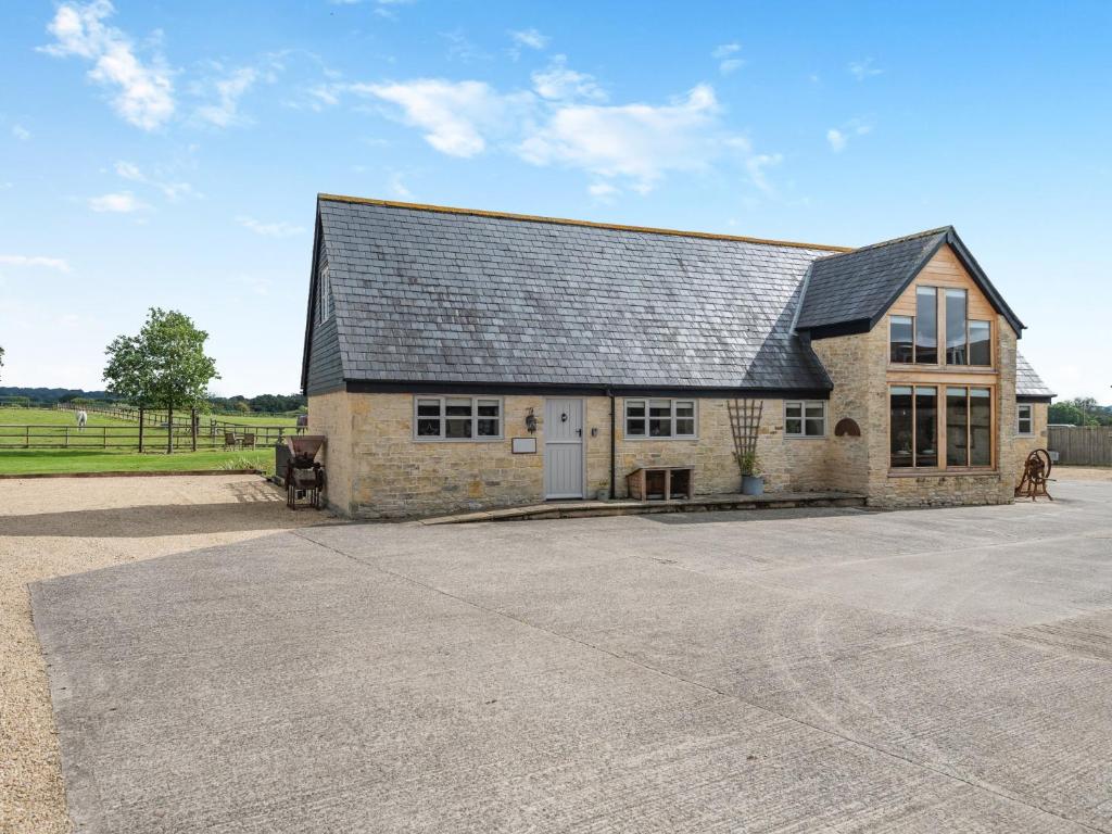 a large stone barn with a black roof at 3 bed in Shaftesbury 85551 in Stour Provost