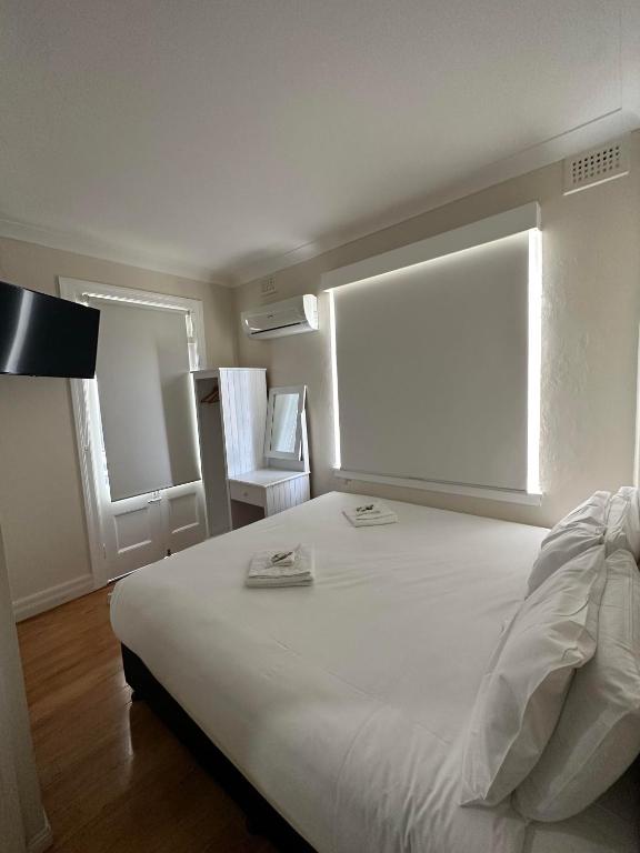 a bedroom with a large white bed with a window at Tattersalls Hotel Casino in Casino