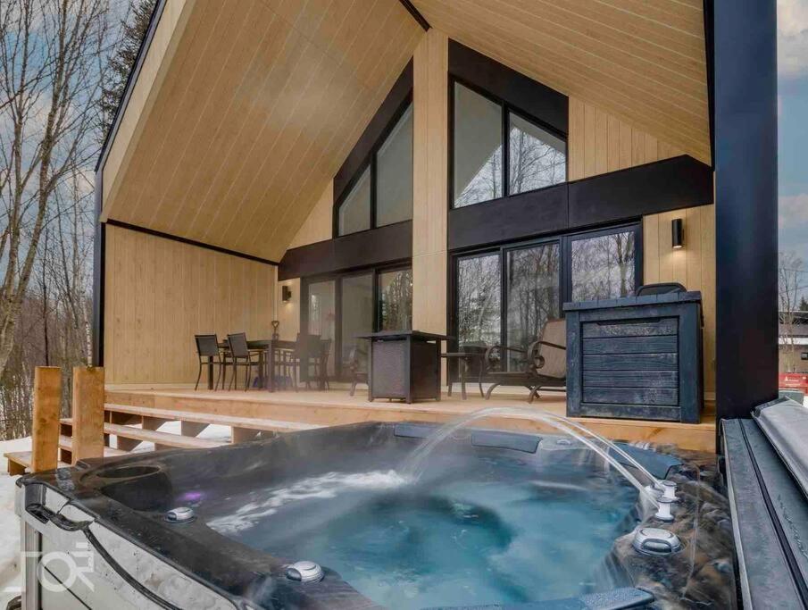 a hot tub in front of a house at Villa Scandinave 3 CAC avec 3 SDB privées & SPA in Pont-Rouge