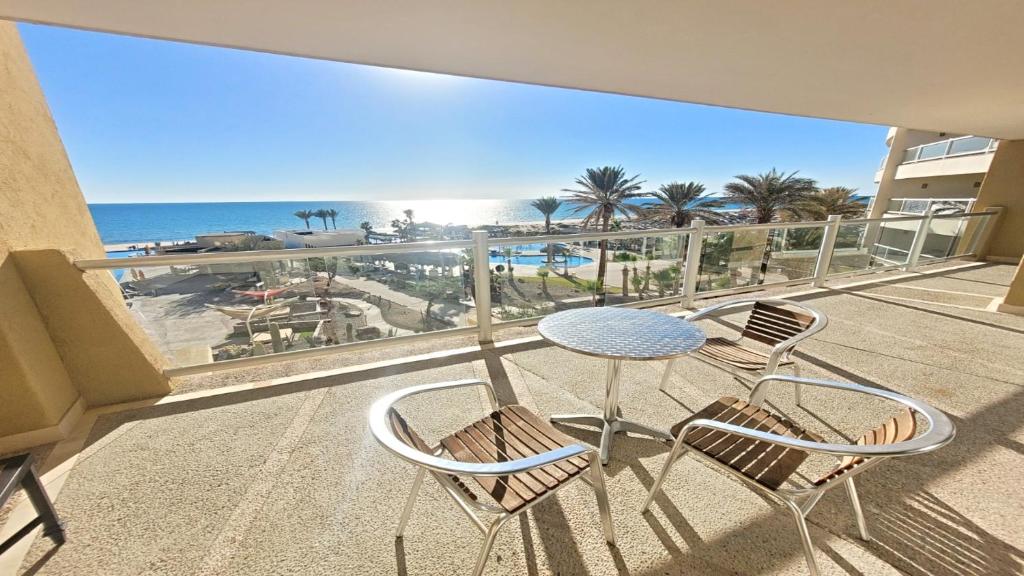 een balkon met een tafel en stoelen en het strand bij Encanto Living 304 Spacious, 2 Bedroom Ocean View!! in Playa Encanto