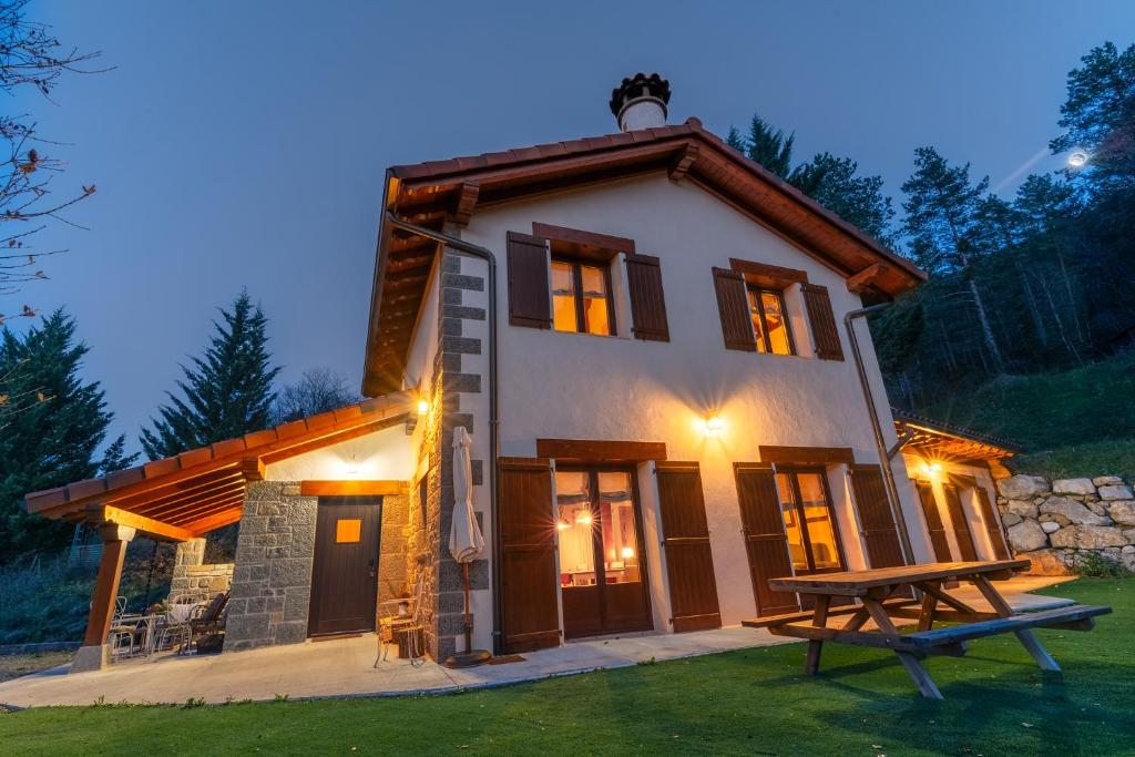 ein Haus mit einem Picknicktisch davor in der Unterkunft Arpetxea casa rural in Roncal